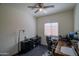 This bedroom features a ceiling fan, neutral walls, and is staged with a dark-colored desk and chair at 2583 N Kenna Pl, Casa Grande, AZ 85122