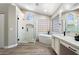 Bright bathroom featuring soaking tub, glass enclosed shower, and double sink vanity at 2702 S Beverly Pl, Chandler, AZ 85286