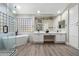 Bright bathroom with white cabinetry, double sinks, soaking tub, and glass enclosed shower at 2702 S Beverly Pl, Chandler, AZ 85286