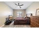 Neutral bedroom featuring a ceiling fan, dresser, and television at 2702 S Beverly Pl, Chandler, AZ 85286