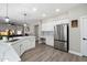 Well-lit kitchen boasts white cabinets, stone countertops, and stainless steel refrigerator at 2702 S Beverly Pl, Chandler, AZ 85286