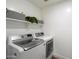 Bright laundry room featuring modern washer and dryer with storage shelves at 2702 S Beverly Pl, Chandler, AZ 85286