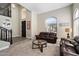 Inviting living room space featuring a dark leather sofa, wood floors, and a view of the home's foyer at 2702 S Beverly Pl, Chandler, AZ 85286