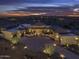 Aerial view of a large desert home at dusk with surrounding desert landscape and city lights in the distance at 30556 N Sage Dr, Peoria, AZ 85383