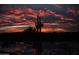 Fiery sunset sky reflected in the pool's water with desert landscape and cacti in the background at 30556 N Sage Dr, Peoria, AZ 85383