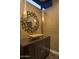 Chic powder room with vessel sink, decorative mirror, and stylish patterned wallpaper at 30556 N Sage Dr, Peoria, AZ 85383