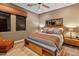 Cozy bedroom with a ceiling fan, large window, bench seating, and neutral color scheme at 30556 N Sage Dr, Peoria, AZ 85383