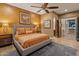 Comfortable bedroom featuring a ceiling fan, warm lighting, and an en-suite bathroom at 30556 W Sage Dr, Peoria, AZ 85383