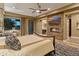 Tastefully decorated bedroom with wood floors, fireplace, television and a view of the backyard at 30556 N Sage Dr, Peoria, AZ 85383