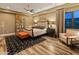 Tastefully decorated bedroom with wood floors, a modern bed frame, a view of the backyard and an elegant rug at 30556 N Sage Dr, Peoria, AZ 85383