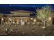 Well-lit front entrance with stone accents, desert landscaping, and a mature tree at 30556 N Sage Dr, Peoria, AZ 85383