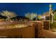 Beautifully landscaped front yard with mature trees, desert plants, and stone accents, illuminated at night at 30556 N Sage Dr, Peoria, AZ 85383