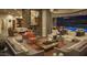Expansive open-concept living area with cozy seating, stone fireplace, and view to the pool at 30556 N Sage Dr, Peoria, AZ 85383