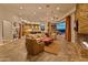 Open-concept living room with stone fireplace, plush seating, and views into the kitchen and outdoor dining area at 30556 N Sage Dr, Peoria, AZ 85383