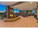 Inviting outdoor living space featuring a fireplace, TV, comfortable seating, and a view of the desert landscape at 30556 N Sage Dr, Peoria, AZ 85383
