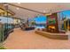 Inviting outdoor living space featuring a fireplace, TV, comfortable seating, and a view of the pool at 30556 N Sage Dr, Peoria, AZ 85383