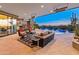 Outdoor patio with comfortable seating, a fireplace, television, and a view of the sparkling pool and desert landscape at 30556 N Sage Dr, Peoria, AZ 85383
