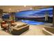 Enjoy this covered outdoor patio with cozy seating, an outdoor kitchen, and a beautiful pool overlooking the desert at 30556 N Sage Dr, Peoria, AZ 85383