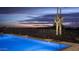 Beautiful pool and fence at dusk, with a view of the city lights and mountain in the distance at 30556 N Sage Dr, Peoria, AZ 85383