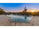Desert landscaping and a pool with a view of the sunset create a serene setting at 30556 N Sage Dr, Peoria, AZ 85383