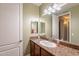 Bathroom featuring granite countertop, framed mirror, and cabinet storage at 3432 E Jasper Dr, Gilbert, AZ 85296