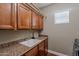 Laundry room with granite countertop, sink, storage cabinets and a window at 3432 E Jasper Dr, Gilbert, AZ 85296