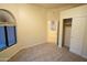 Beige bedroom featuring a carpet, closet, ceiling fan, and arched windows with view at 37509 N 7Th N St, Phoenix, AZ 85086