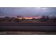 Dusk photograph of a road running through the desert, with a sunset in the background at 37509 N 7Th N St, Phoenix, AZ 85086