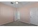 A pink-walled bedroom with neutral carpet and two white doors, one leading to the staircase at 38 S 197Th Ln, Buckeye, AZ 85326