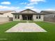 A flat backyard with green turf and large paver patio at 41285 W Sussex Dr, Maricopa, AZ 85138