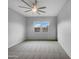 Spacious, well-lit bedroom with carpet flooring, ceiling fan, and a view from the window at 41285 W Sussex Dr, Maricopa, AZ 85138