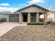 Charming single-story home with stone accents and a well-manicured front yard with desert landscaping at 41285 W Sussex Dr, Maricopa, AZ 85138