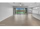 Spacious open-concept living room area with neutral paint, tile floors, and sliding glass doors at 41285 W Sussex Dr, Maricopa, AZ 85138