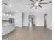 Spacious living room with tile flooring, a modern ceiling fan, and an open layout into the kitchen and hallway at 41285 W Sussex Dr, Maricopa, AZ 85138