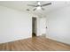 Spacious bedroom with a ceiling fan, wood-look floors, and an open doorway at 4336 N 93Rd Dr, Phoenix, AZ 85037