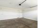 Spacious two-car garage with bright lighting, concrete floors, and two access doors at 4336 N 93Rd Dr, Phoenix, AZ 85037