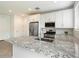 Stylish kitchen with stainless steel appliances, granite countertops, and white cabinets at 4336 N 93Rd Dr, Phoenix, AZ 85037