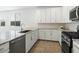 Well-lit kitchen features granite countertops, white cabinets, and a gas range at 4336 N 93Rd Dr, Phoenix, AZ 85037