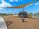 Community playground with climbing structures, spring riders and a covered picnic area at 4336 N 93Rd Dr, Phoenix, AZ 85037