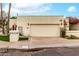 Beige stucco home with a two car garage, verdant landscaping, and a charming signpost with address at 4725 E Winston Dr, Phoenix, AZ 85044