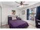 This bedroom boasts a large window, ceiling fan and comfortable bed with a purple comforter at 614 W Morrow Dr, Phoenix, AZ 85027