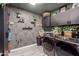 Laundry room with stylish wallpaper, black cabinetry and new washer and dryer at 614 W Morrow Dr, Phoenix, AZ 85027
