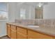 Bathroom featuring double sinks, granite countertops, tile backsplash, and glass enclosed shower at 7325 W Williams St, Phoenix, AZ 85043