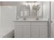 Bathroom features a white double vanity with a tub and shower at 8541 N 112Th Ave, Peoria, AZ 85345