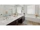 Bathroom with dual sinks, lots of counter space, and a tub with glass block windows at 9390 N 115Th St, Scottsdale, AZ 85259