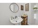 Stylish pedestal sink with round mirror, decorative accents, and organized storage baskets at 9390 N 115Th St, Scottsdale, AZ 85259