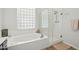 Modern bathroom features a jacuzzi tub and clear glass shower with wood-look tile flooring at 9390 N 115Th St, Scottsdale, AZ 85259