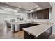 Kitchen with a breakfast bar, stainless steel appliances, dark wood cabinets, and an adjacent seating area at 9390 N 115Th St, Scottsdale, AZ 85259