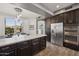 Kitchen featuring an island with seating, dark wood cabinets, and stainless steel appliances at 9390 N 115Th St, Scottsdale, AZ 85259