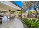 Inviting covered back patio features a ceiling fan, seating, and access to the refreshing pool and well manicured backyard at 1002 E Grandview Rd, Phoenix, AZ 85022